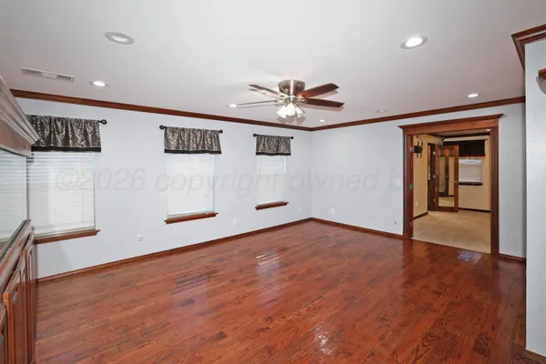 a view of empty room with wooden floor