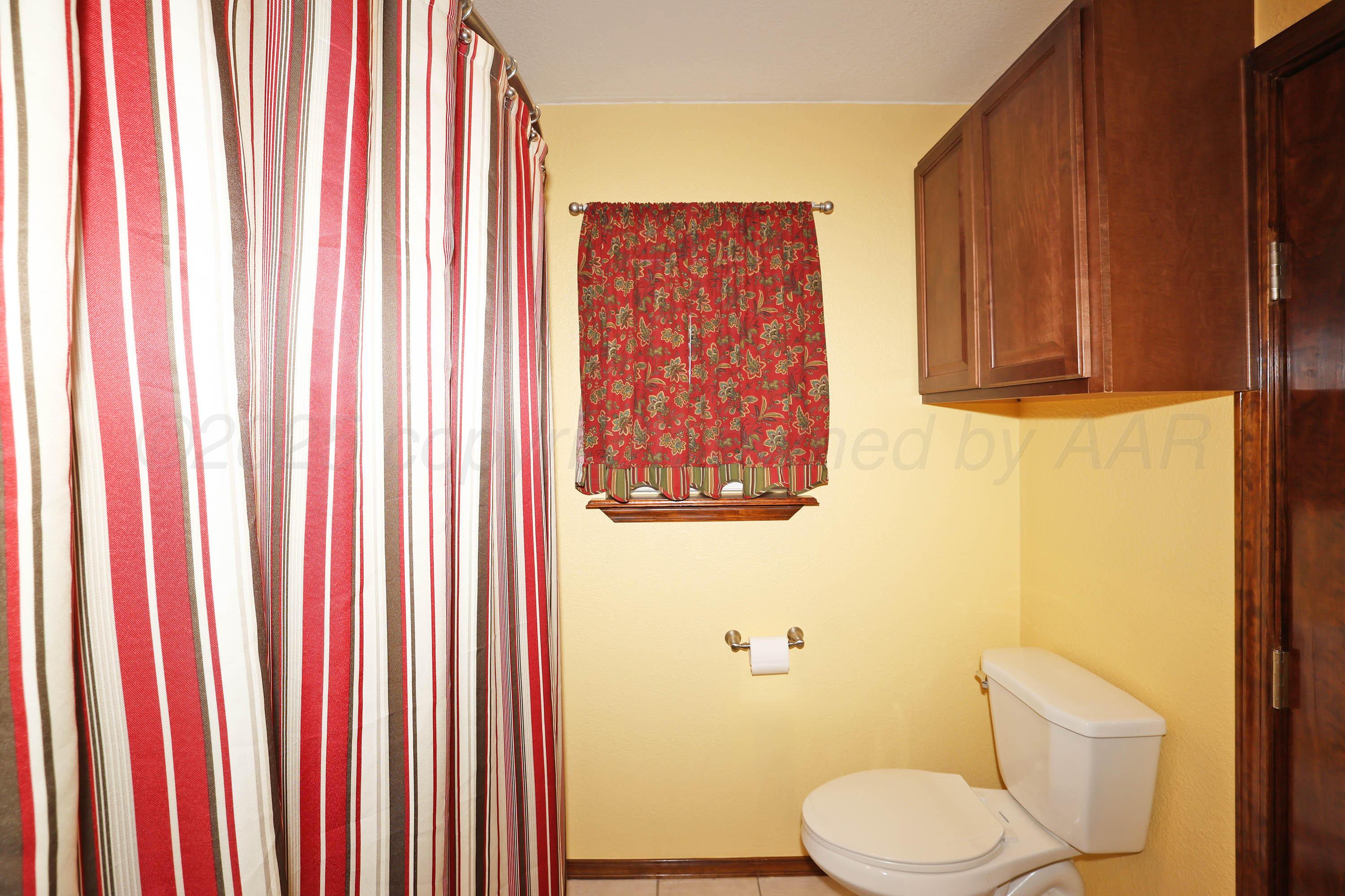 7722 Canode Drive Amarillo, TX 79121 - Photo 27 of 40 a white toilet sitting next to a curtain