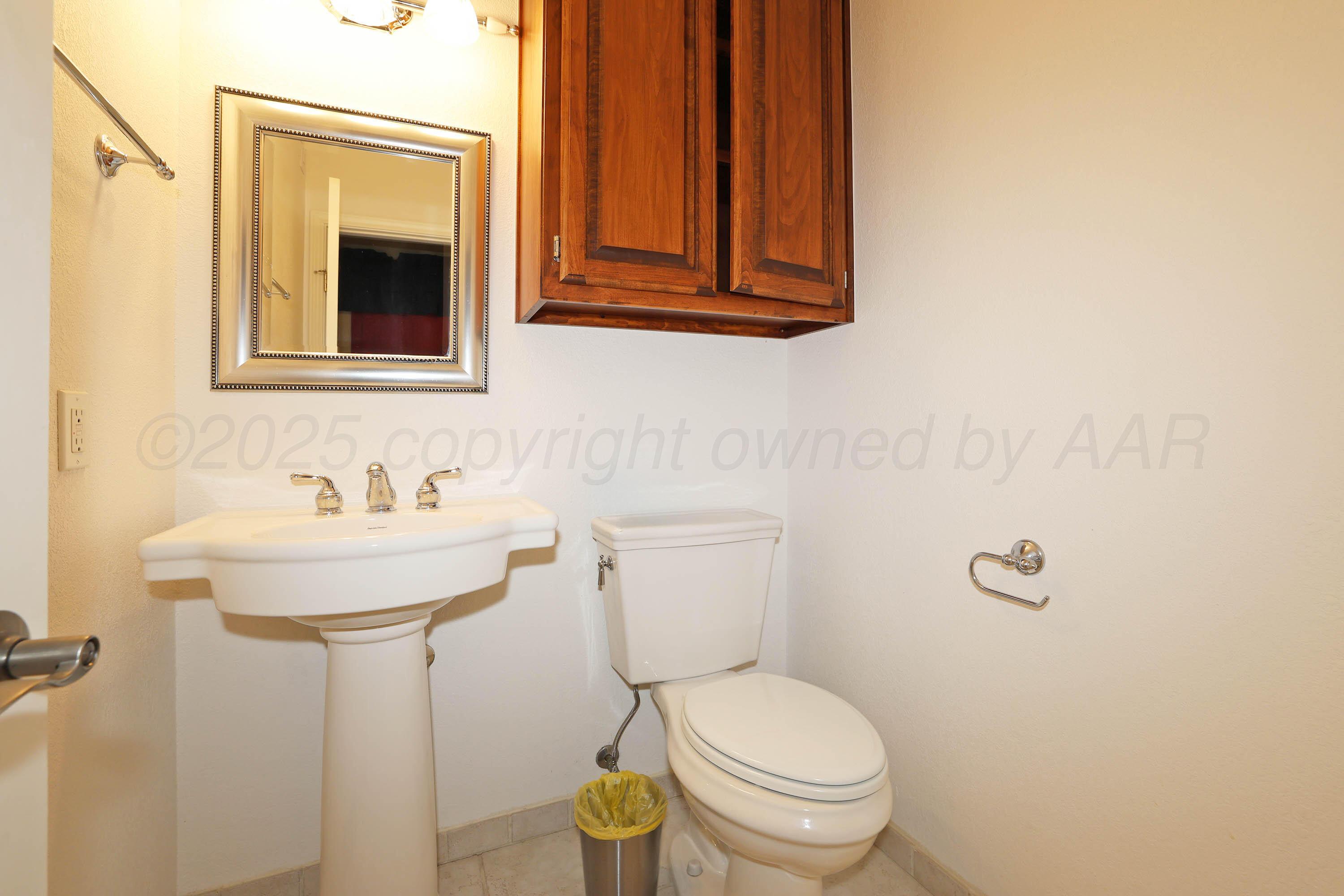 7722 Canode Drive Amarillo, TX 79121 - Photo 31 of 40 a bathroom with a sink a toilet and mirror