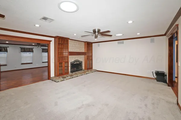 a view of an empty room with a fireplace and a window