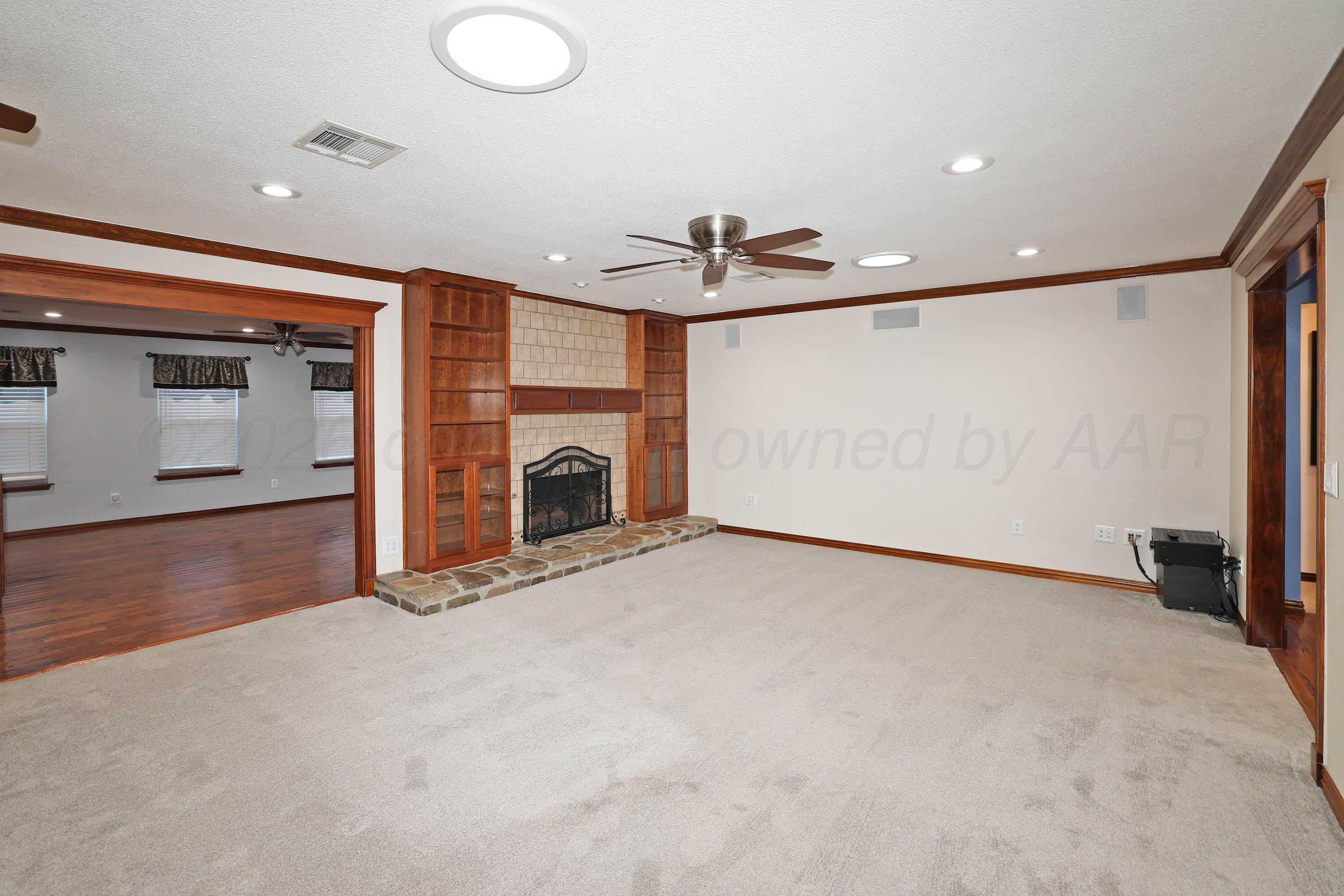 7722 Canode Drive Amarillo, TX 79121 - Photo 6 of 40 a view of an empty room with a fireplace and a window