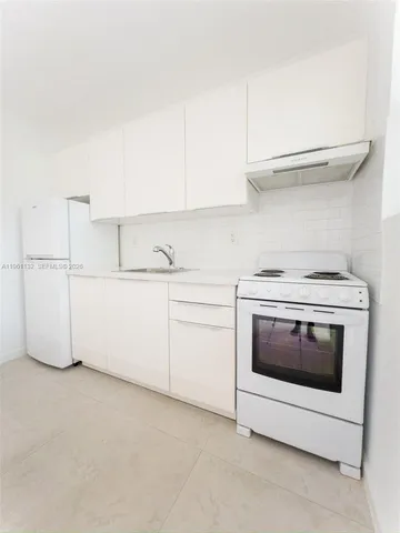 a kitchen with cabinets and white stainless steel appliances