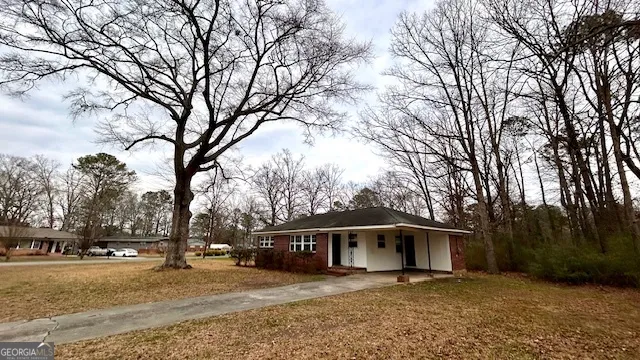 a front view of a house with a yard and trees