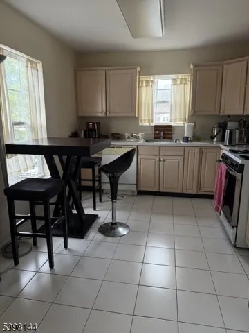 a kitchen with a sink a stove a table and chairs in it