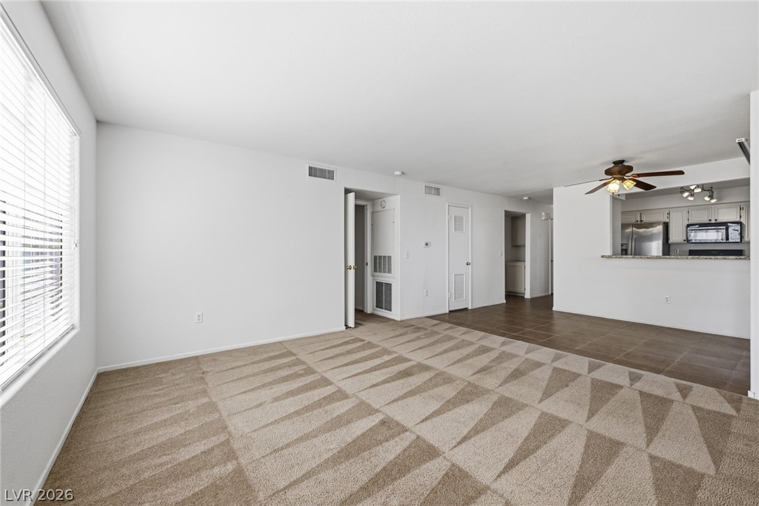1851 Hillpointe Road, Unit 1311 Henderson, NV 89074 - Photo 12 of 47 Unfurnished living room with a ceiling fan, light carpet, and light tile patterned floors