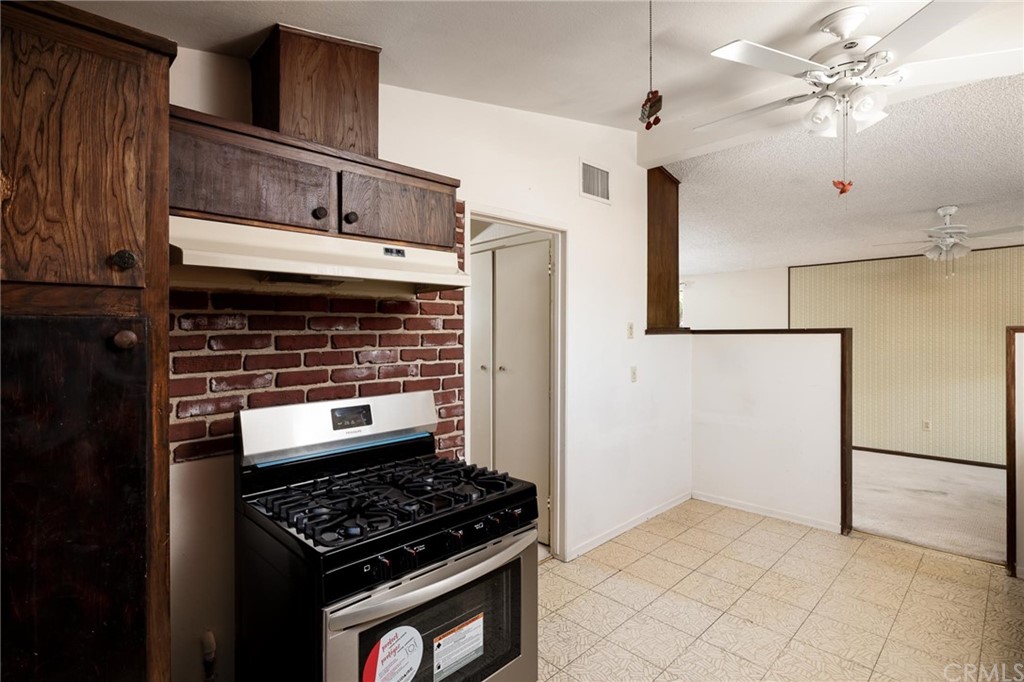 12540 Taunt Place Poway, CA 92064 - Photo 14 of 36 a kitchen with granite countertop a stove and a refrigerator with white cabinets