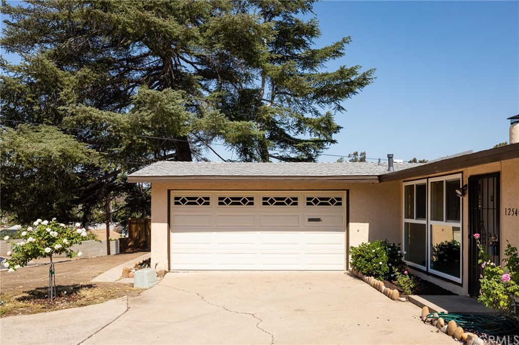 12540 Taunt Place Poway, CA 92064 - Photo 6 of 36 a front view of a house with a yard and garage