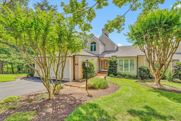 a front view of a house with yard and green space