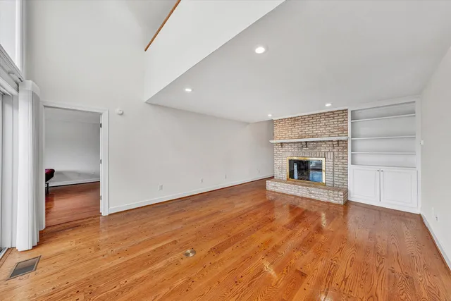 a view of empty room with wooden floor and fireplace
