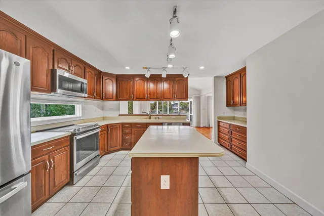 a kitchen with stainless steel appliances granite countertop a stove a sink and a microwave