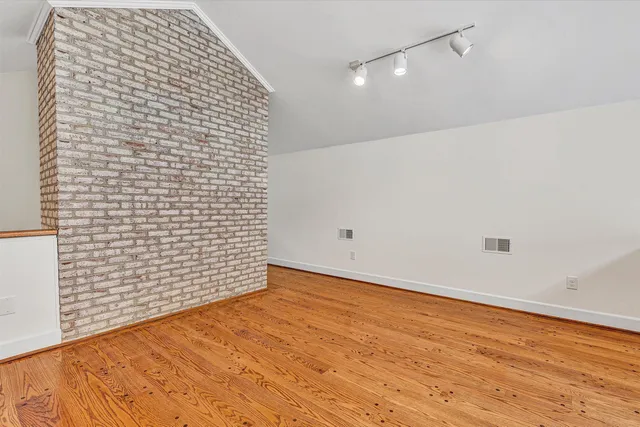 a view of empty room with wooden floor and fireplace