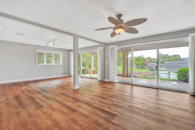a view of an empty room with a fireplace and window