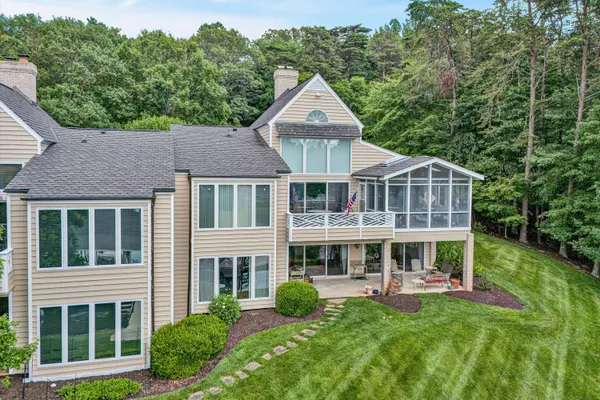 a kitchen with stainless steel appliances granite countertop a stove top oven a refrigerator a sink and dishwasher with wooden cabinets