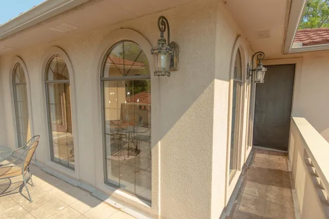 a bedroom with a bed a desk and chair with window