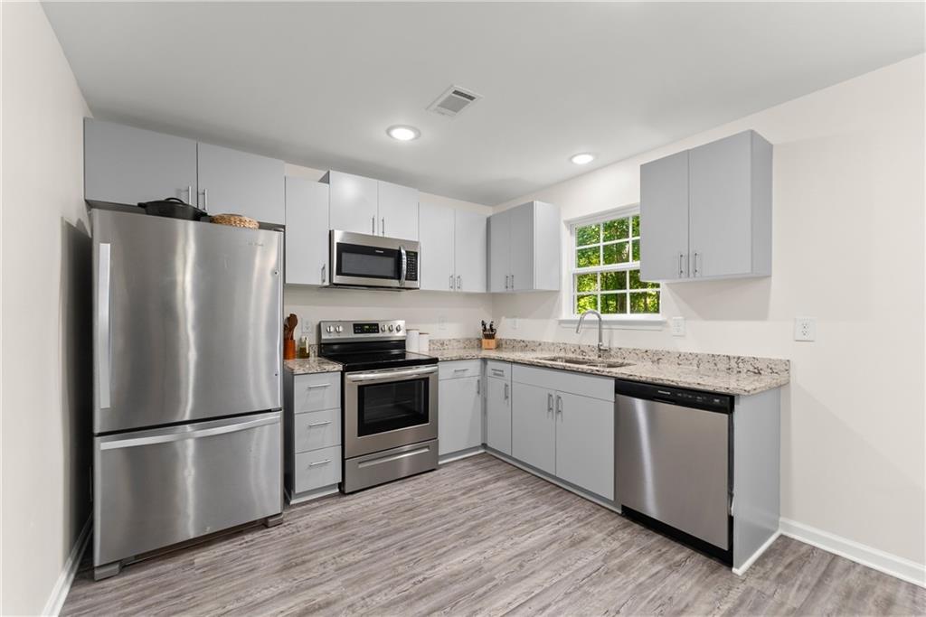 2407 Thompson Mill Road Gainesville, GA 30506 - Photo 15 of 35 a kitchen with stainless steel appliances granite countertop a refrigerator stove microwave and sink