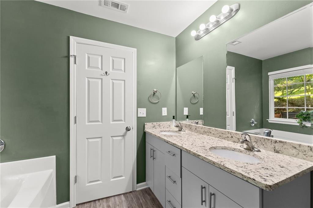 2407 Thompson Mill Road Gainesville, GA 30506 - Photo 23 of 35 a bathroom with a granite countertop sink and a mirror