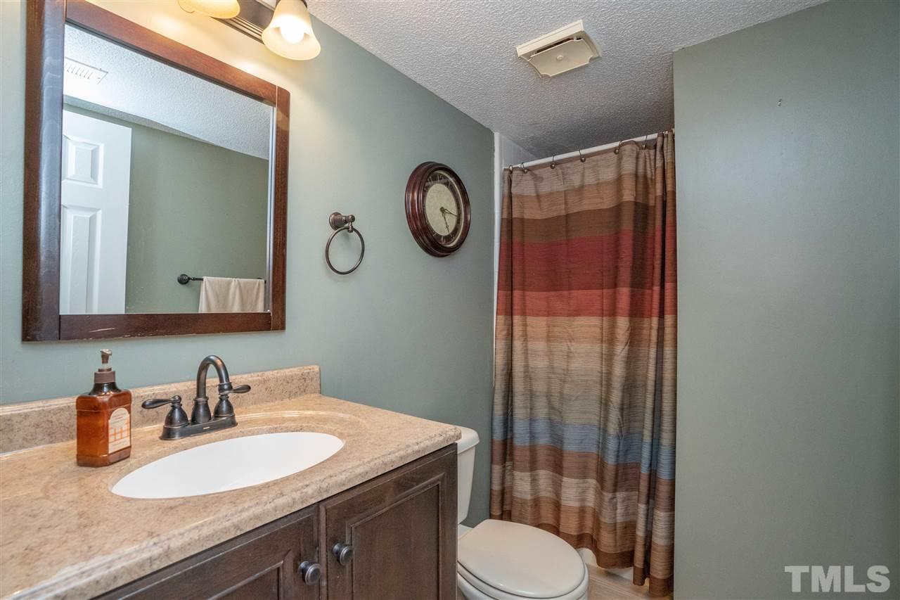 7500 Mine Valley Road Raleigh, NC 27615 - Photo 15 of 25 a bathroom with a granite countertop toilet a sink and a mirror