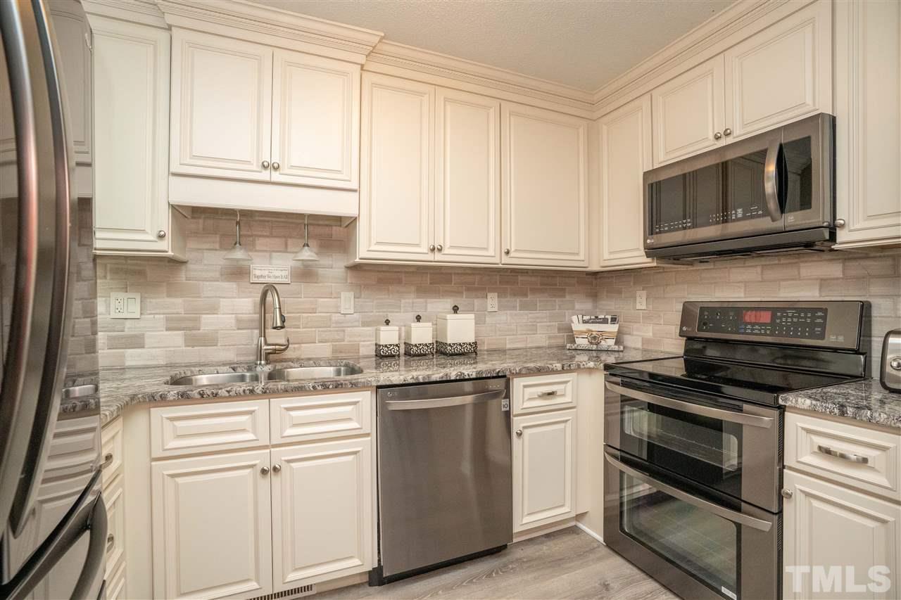 7500 Mine Valley Road Raleigh, NC 27615 - Photo 8 of 25 a kitchen with stainless steel appliances granite countertop grey cabinets a stove a sink and dishwasher