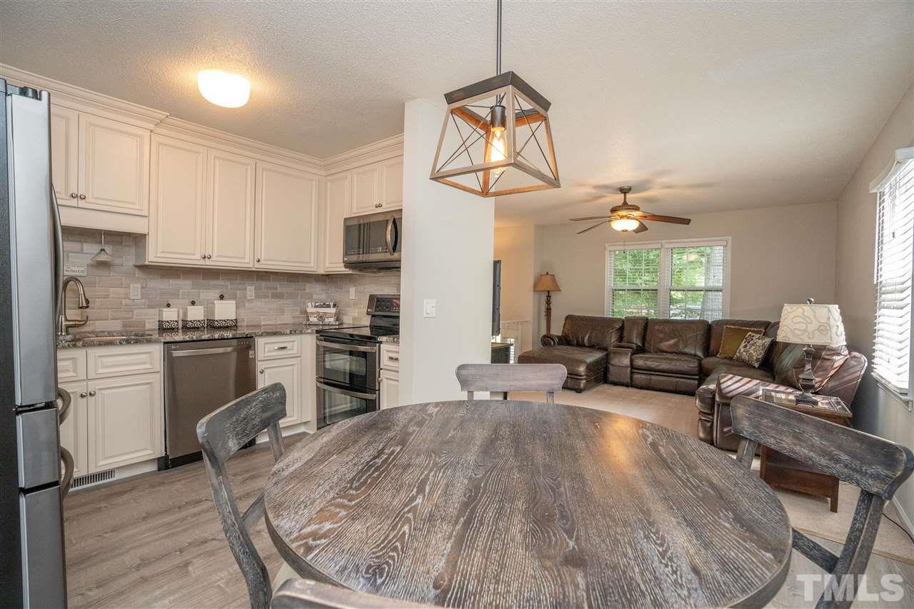 7500 Mine Valley Road Raleigh, NC 27615 - Photo 9 of 25 a kitchen with a refrigerator a stove cabinets and couches with wooden floor