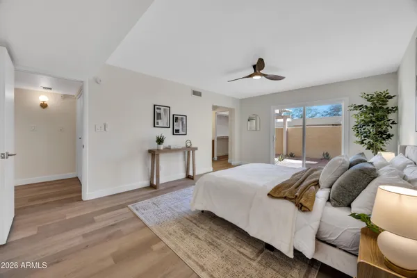 a spacious bedroom with a bed chandelier and a window