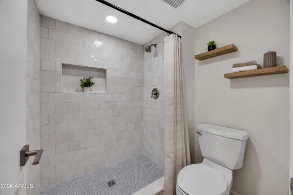 a bathroom with a toilet and a shower