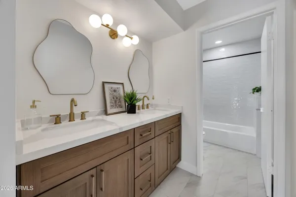 a bathroom with a sink a vanity a mirror and a bathtub