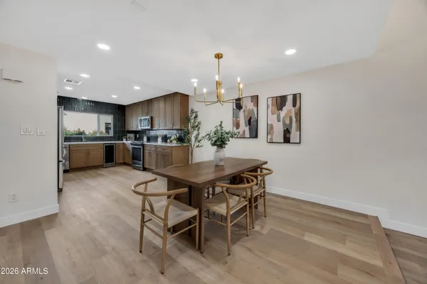 a kitchen with kitchen island a dining table chairs stainless steel appliances and cabinets