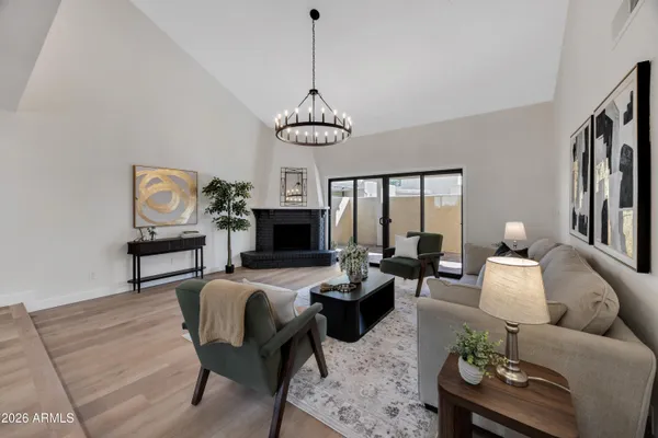 a living room with furniture a chandelier and a fireplace
