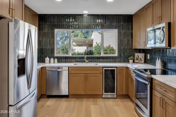 a kitchen with stainless steel appliances granite countertop a refrigerator a sink and a stove