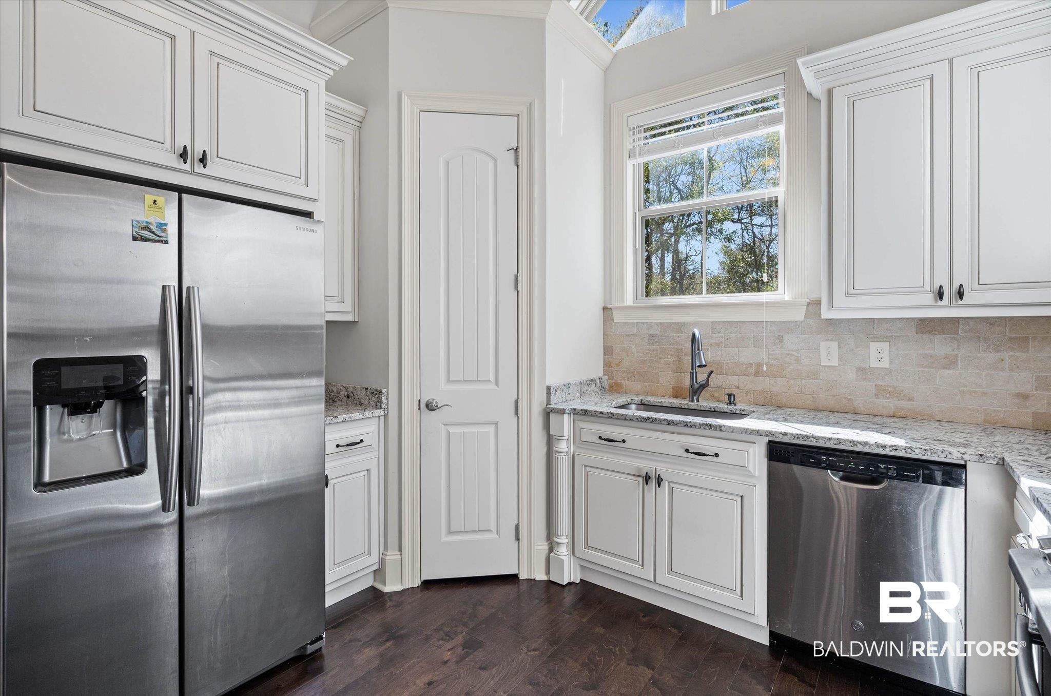 3528 Rue Royal Mobile, AL 36693 - Photo 11 of 53 Kitchen with stainless steel appliances, white cabinets, light stone counters, and dark wood-type flooring