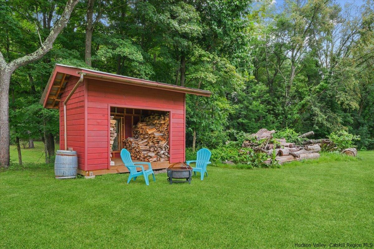 45 Pine Bush Road Stone Ridge, NY 12484 - Photo 27 of 34 a view of a backyard with table and chairs and potted plants and large trees