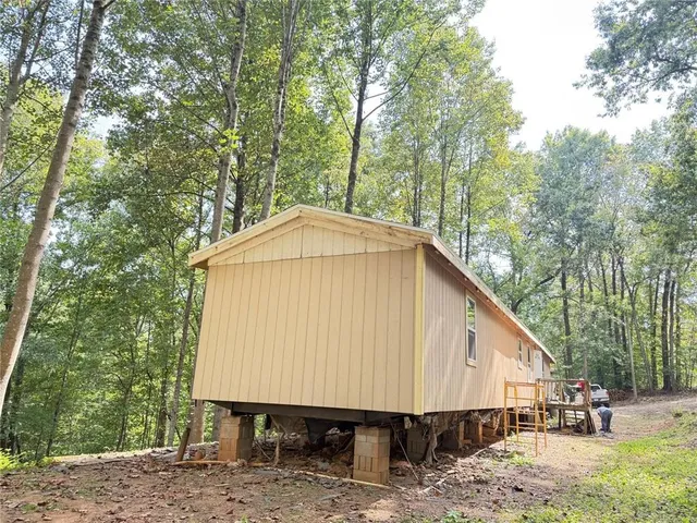 a view of a small house with a yard and roof