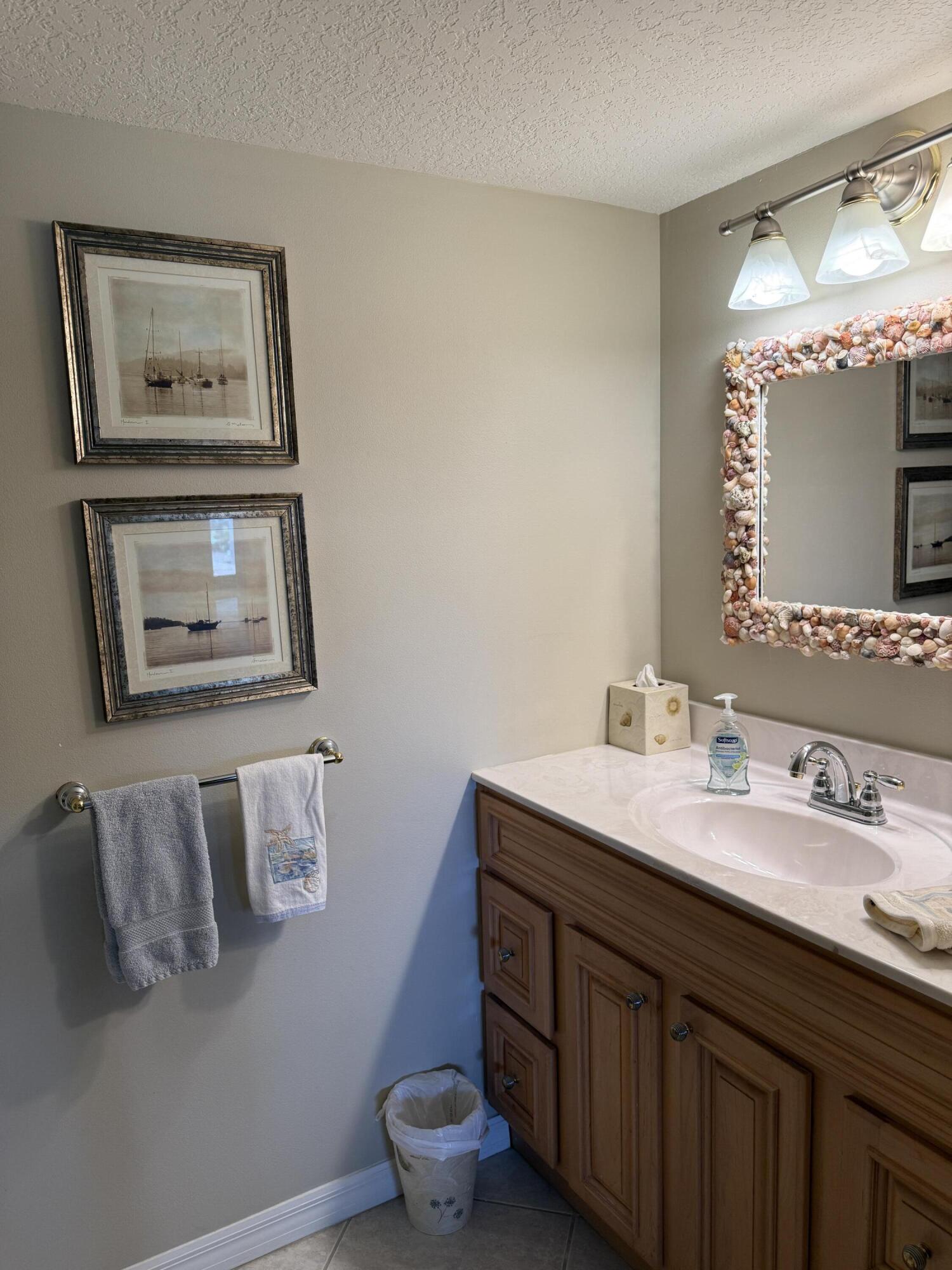 2400 South Ocean Drive, Unit 1034 Fort Pierce, FL 34949 - Photo 22 of 51 a bathroom with a toilet a sink and mirror