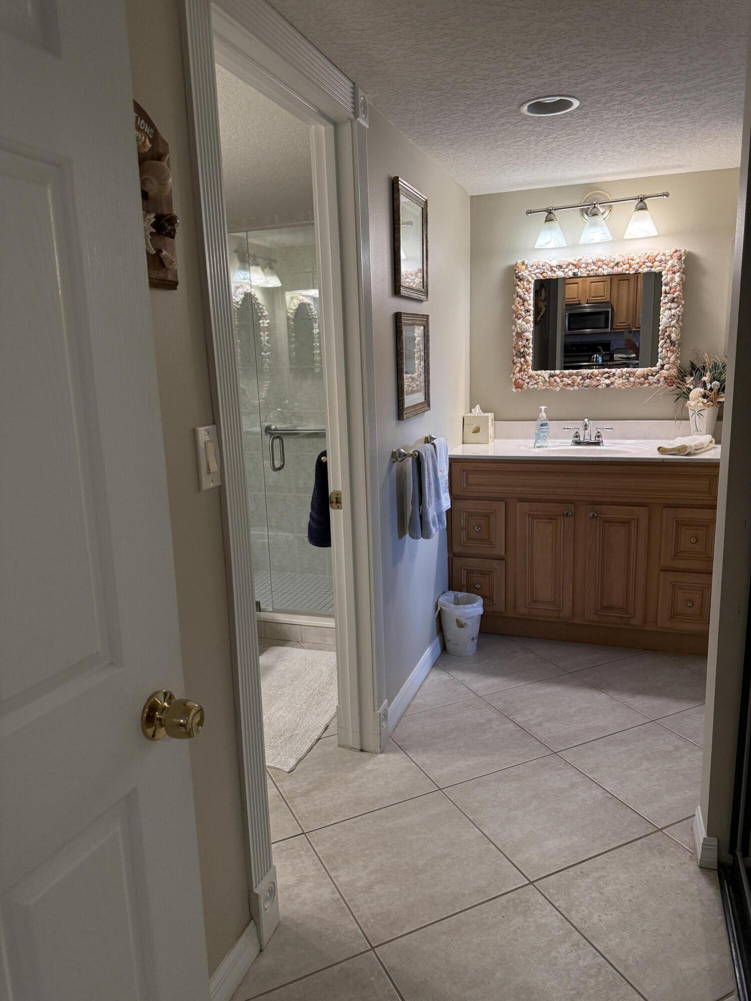 2400 South Ocean Drive, Unit 1034 Fort Pierce, FL 34949 - Photo 25 of 51 a large bathroom with a glass door shower and mirror
