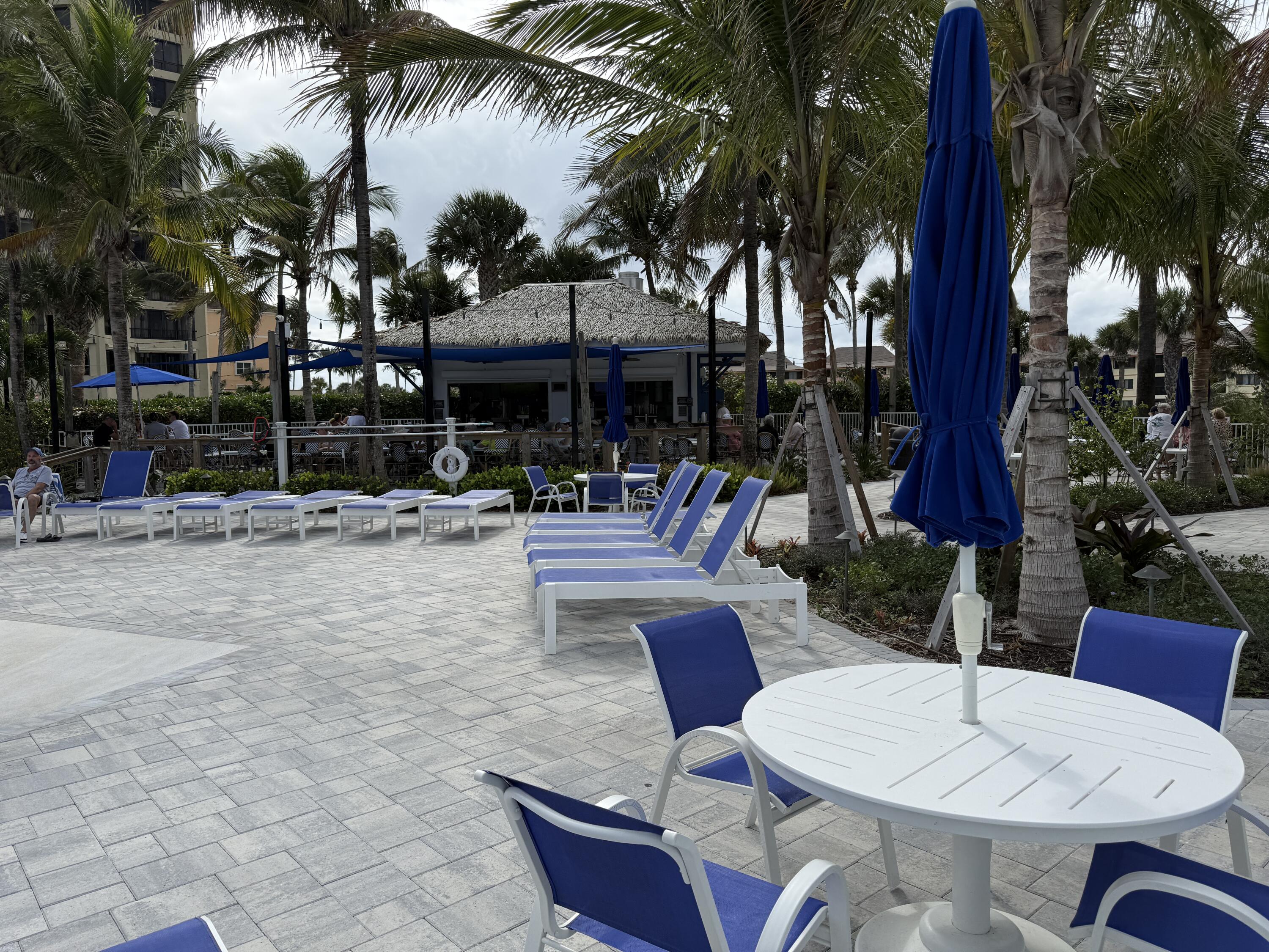 2400 South Ocean Drive, Unit 1034 Fort Pierce, FL 34949 - Photo 36 of 51 a view of a patio with table and chairs potted plants and palm tree