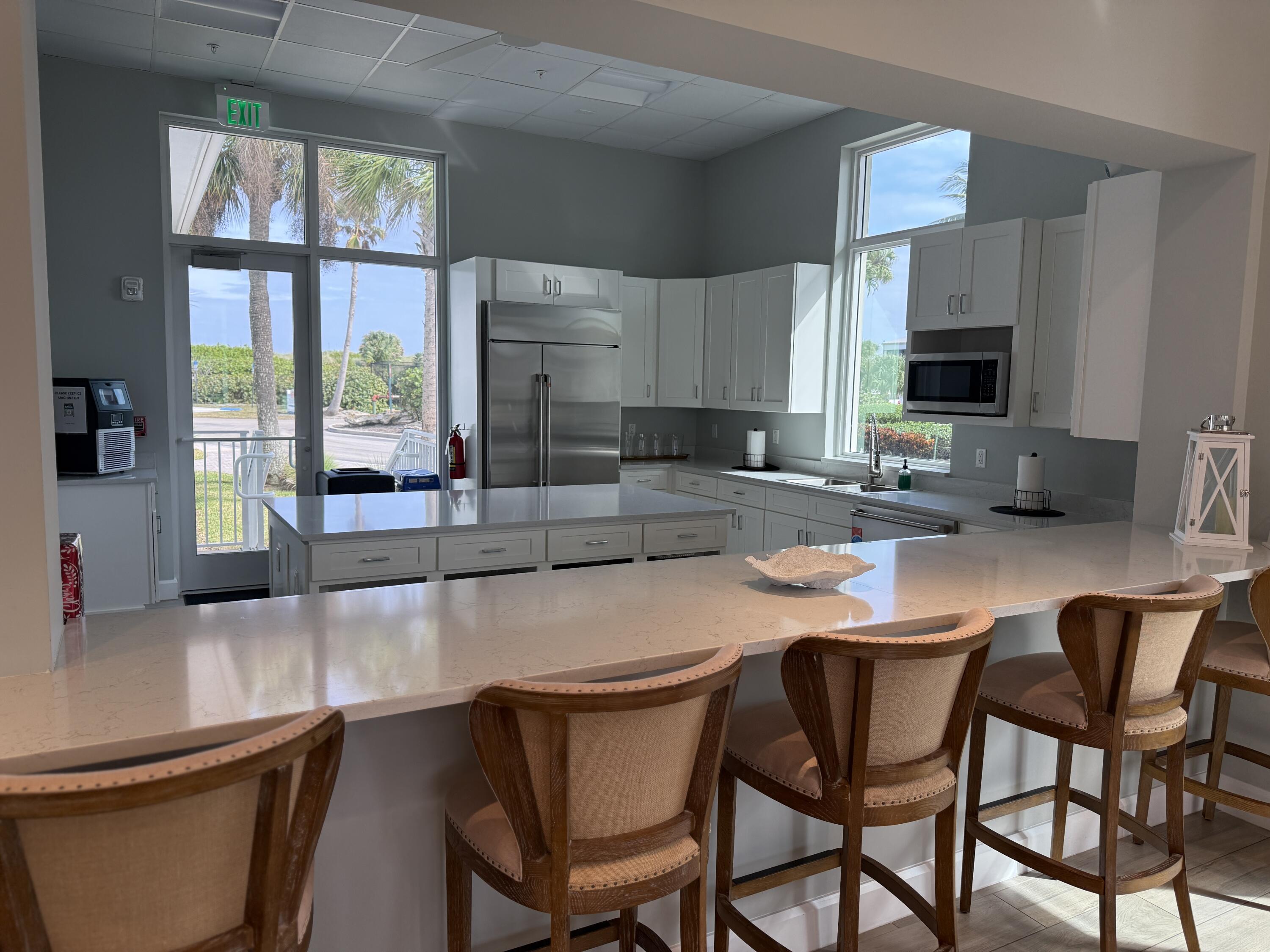 2400 South Ocean Drive, Unit 1034 Fort Pierce, FL 34949 - Photo 47 of 51 a kitchen with a table chairs sink and cabinets