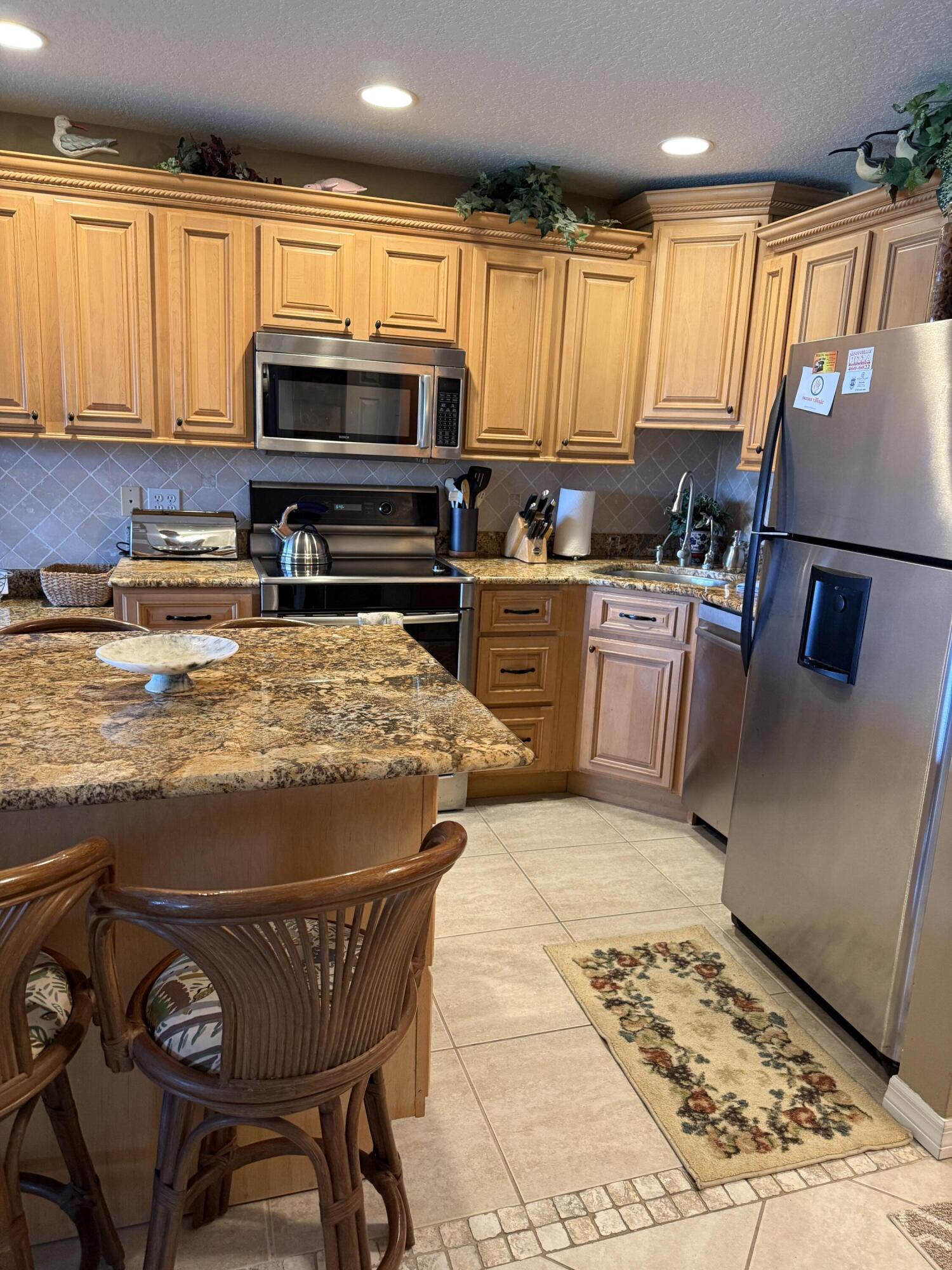 2400 South Ocean Drive, Unit 1034 Fort Pierce, FL 34949 - Photo 6 of 51 a kitchen with stainless steel appliances granite countertop a stove top oven a sink a dining table and chairs with wooden floor