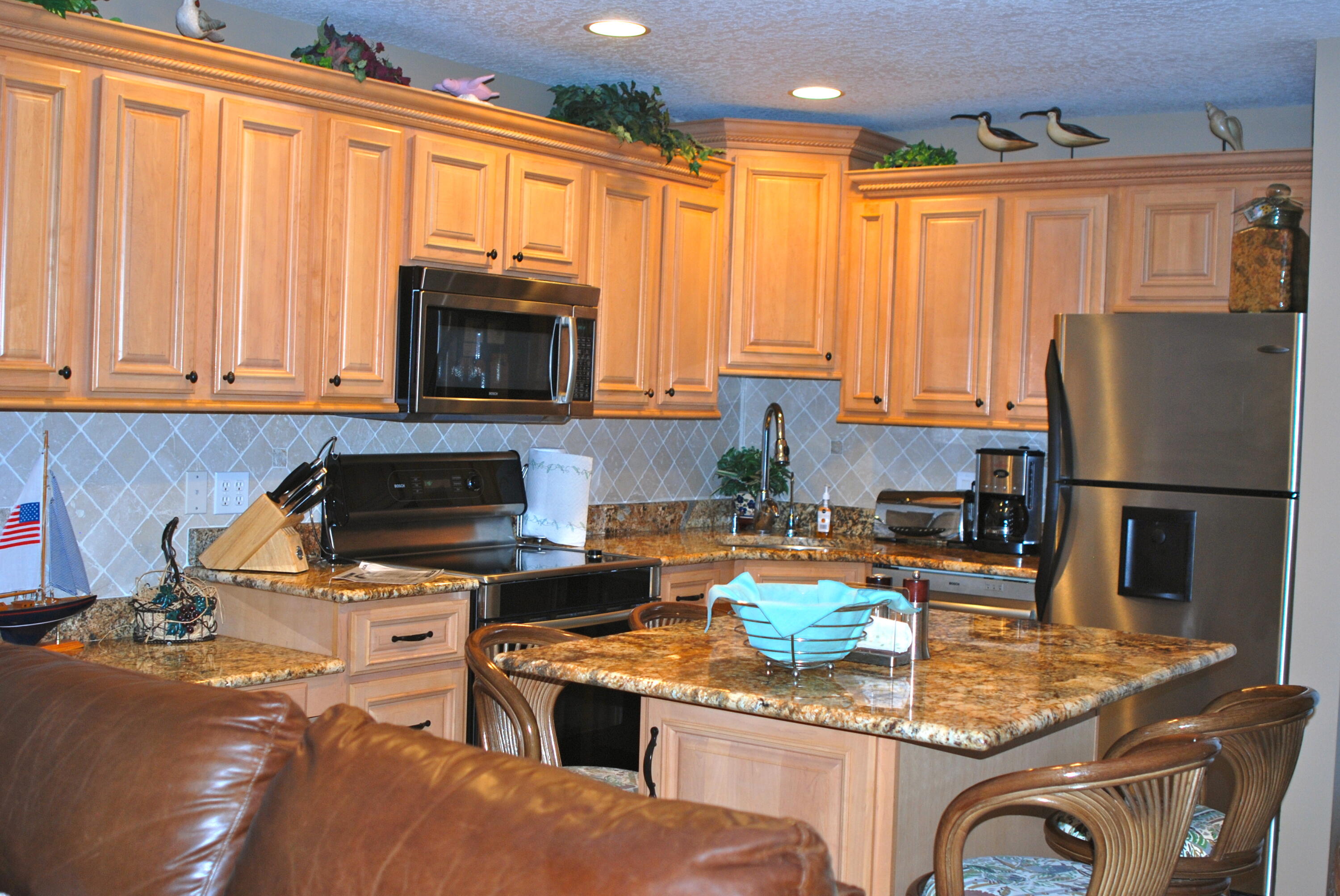 2400 South Ocean Drive, Unit 1034 Fort Pierce, FL 34949 - Photo 7 of 51 a kitchen with stainless steel appliances granite countertop a stove top oven a sink dishwasher and refrigerator with wooden floor