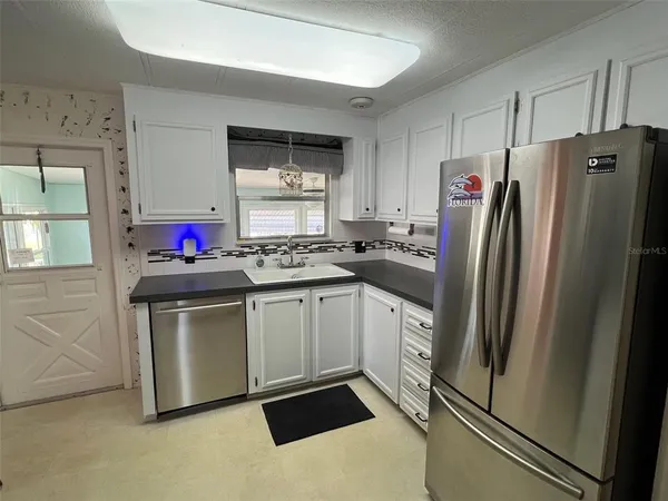 a kitchen with stainless steel appliances a refrigerator sink and microwave