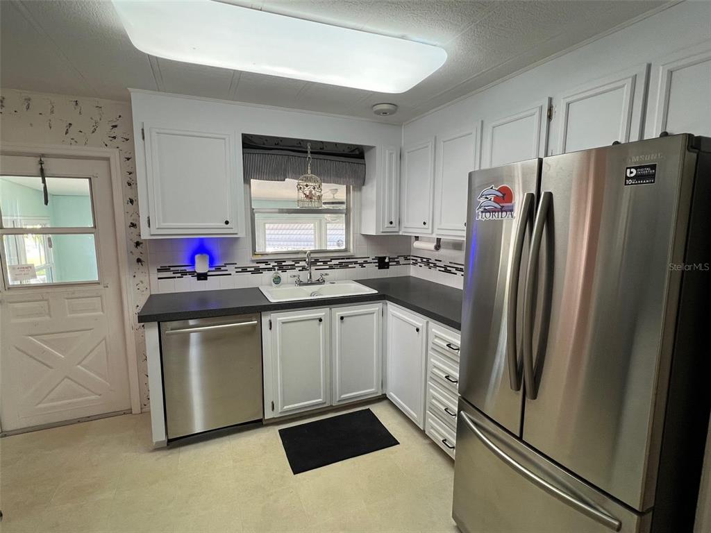 701 Sugar Palm Street Largo, FL 33770 - Photo 11 of 30 a kitchen with stainless steel appliances a refrigerator sink and microwave