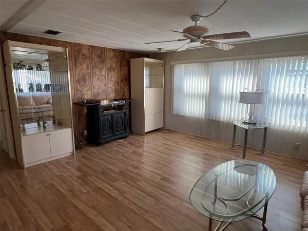 a livingroom with furniture wooden floor a rug and a window