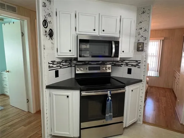 a kitchen with stainless steel appliances a stove a microwave and a refrigerator