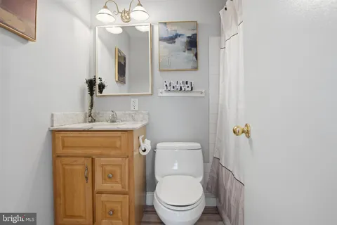 a bathroom with a granite countertop toilet sink and mirror