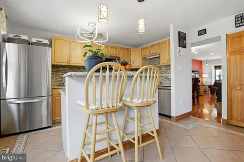 a kitchen with stainless steel appliances granite countertop a refrigerator a stove a microwave oven with a dining table and chairs