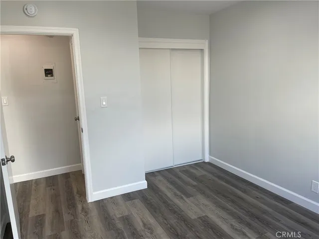 an empty room with wooden floor and closet