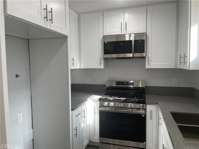 a kitchen with stainless steel appliances a stove a microwave and cabinets