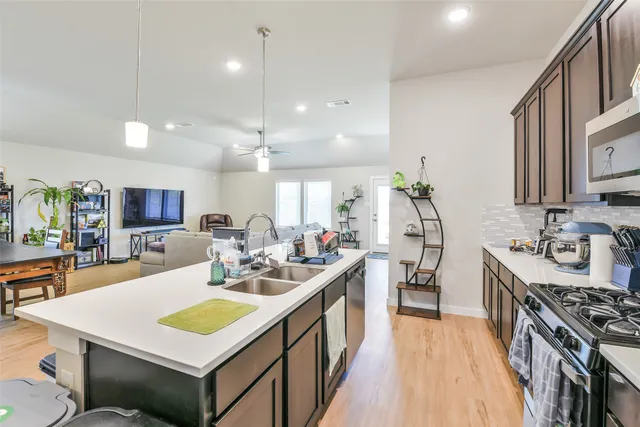 a large kitchen with kitchen island a sink counter space and stainless steel appliances