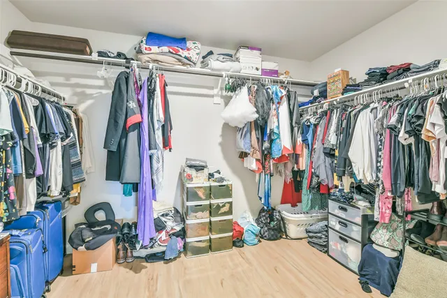 a view of walk in closet with clothes