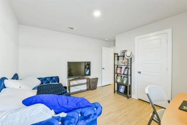 a bedroom with furniture and a flat screen tv
