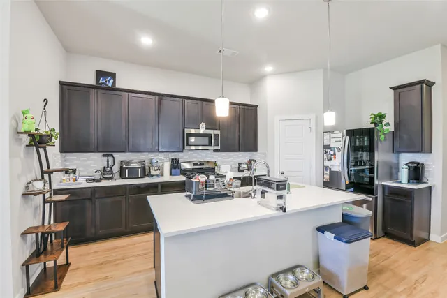 a kitchen with a sink refrigerator and cabinets